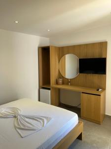 Un dormitorio con una cama y un escritorio con espejo. en Koks’ Guesthouse, en Himare
