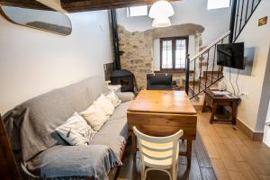 a living room with a couch and a wooden table at Casa Rural La Barquilla in Acebo