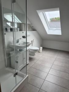 a bathroom with a toilet and a skylight at Ferienwohnung Immenzaun in Isernhagen +8 photos