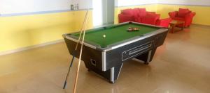 a pool table in a room with red chairs at Hôtel chez Marie Oyouma in Port-Gentil