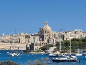 une vue d'une ville avec des bateaux dans l'eau dans l'établissement The Londoner Hotel Sliema, à Sliema