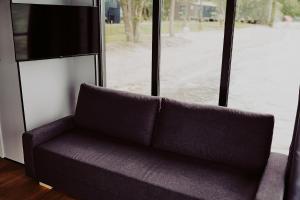 a couch sitting in front of a window at Houseboats Dollar - Plaża Nowe Guty in Nowe Guty