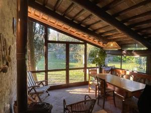 a screened in porch with a wooden table and chairs at La Bicocca in Montegrotto Terme