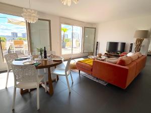 een woonkamer met een rode bank en een tafel bij Le Penthouse Ampère in Nanterre