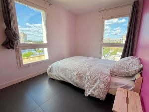 een slaapkamer met een bed en twee ramen bij Le Penthouse Ampère in Nanterre