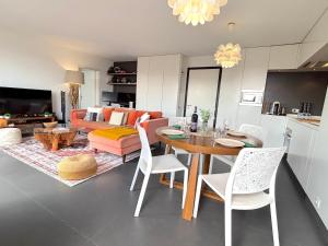 een keuken en woonkamer met een tafel en een bank bij Le Penthouse Ampère in Nanterre