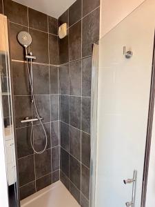 een douche met een douchekop in een badkamer bij Le Penthouse Ampère in Nanterre +39 foto's