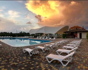 a group of lounge chairs and a swimming pool at Apartments Promenad in Zatoka