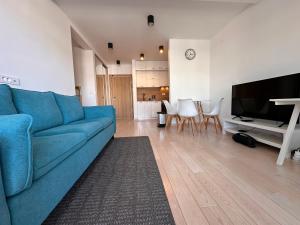 a living room with a blue couch and a television at River side 18 in Herceg-Novi