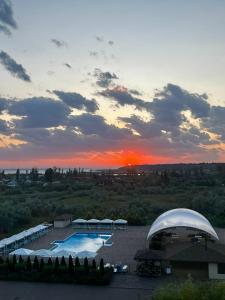 a view of a pool with a sunset in the background at Apartments Promenad in Zatoka +4 photos