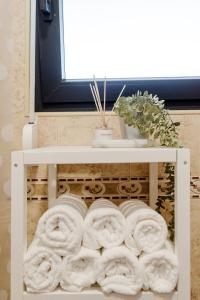 un estante lleno de toallas en el baño en Quinta Alto da Capela, en Setúbal