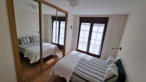 Un dormitorio con un espejo y una cama dentro. en Casa Villamor de Orbigo, 