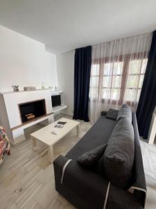 Una sala de estar con un sofá y una chimenea. en Luna Dorada Vera Playa- bajo, en Los Amarguillos