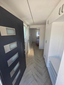 a room with a white refrigerator and a wooden floor at Green Home Bihać in Bihać