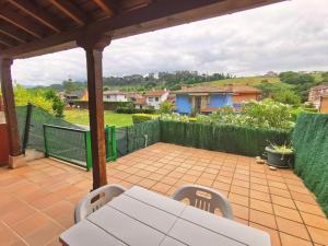 a patio with a white table and chairs on it at Playa Ribadesella Cris in Ribadesella
