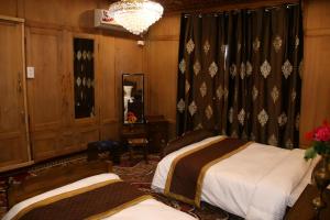 a bedroom with two beds and a chandelier at Peace Of Mind Group of Houseboats in Srinagar +6 photos