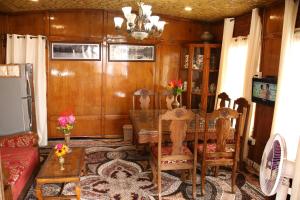 a living room with a table and chairs and a couch at Peace Of Mind Group of Houseboats in Srinagar