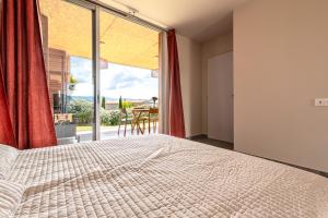 a bedroom with a bed and a large window at Splendide appartement T3 piscine et vue mer in Grosseto-Prugna