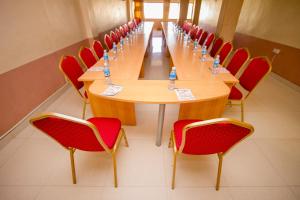 a conference room with a long table and red chairs at Silver Bells Hotel in Isiolo