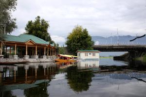 a building on the water next to a bridge at Peace Of Mind Group of Houseboats in Srinagar