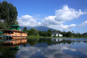 a boat on a lake with a house on it at Peace Of Mind Group of Houseboats in Srinagar