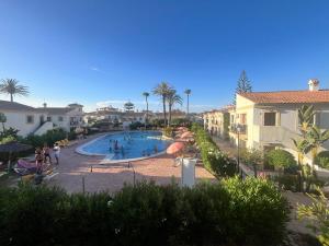 Una piscina en un complejo turístico con gente en ella. en Luna Dorada Vera Playa- bajo, en Los Amarguillos