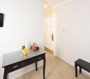 a room with a table with drinks and flowers on it at Hotel Toboso Chaparil in Nerja