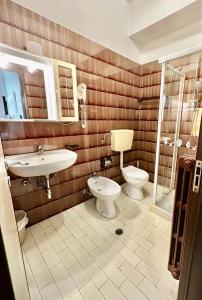 a bathroom with a toilet and a sink and a shower at Hotel Splendid Suisse in Bellaria-Igea Marina