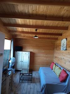 sala de estar con sofá en una sala de madera en Chalet 35m2 Domaine du vieux chêne, en Bergerac