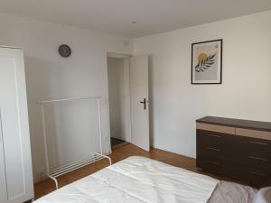 an empty bedroom with a bed and a dresser at Au cœur de l'Alsace in Duttlenheim