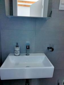 a white sink in a bathroom with a mirror at Appartment Brani & Mira in Rukavac +13 photos