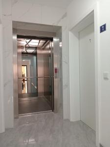 a hallway with a mirror in a building at Apartments Karić Aerodrom Tuzla in Dubrave Gornje +25 photos