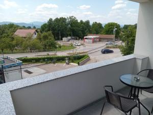 a balcony with a table and chairs and a view of a parking lot at Apartments Karić Aerodrom Tuzla in Dubrave Gornje