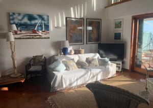 a living room with a white couch and a tv at Casa Stefania in Anzio