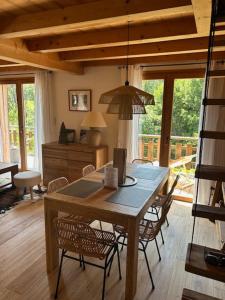 een eetkamer met een houten tafel en stoelen bij Le chalet Leïla in Manigod