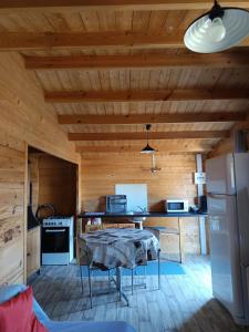una cocina con una mesa y un refrigerador en Chalet 35m2 Domaine du vieux chêne, en Bergerac
