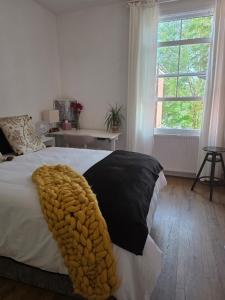 a bedroom with a bed with a blanket on it at Walk to Wembley Stadium and Arena 2 Bedroom Sleeps 4 in London