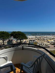 a view of the beach from a balcony with two chairs at Hotel Splendid Suisse in Bellaria-Igea Marina