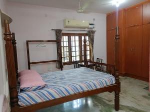 a bedroom with a bed and a window at Thuyil Home Stay in Tirunelveli +18 photos