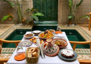 a table with plates of food on top of it at Riad Dar Timrad in Fez +104 photos
