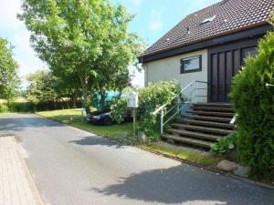 a house with stairs and a car parked next to it at Ferienwohnung Lange Erdgeschoss in Maasholm-Bad
