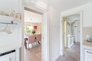 a kitchen and dining room with white walls and a table at Avenarius Hüs in Kampen +30 photos