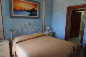 a bedroom with a bed and a painting on the wall at Villa 7 posti a 3 minuti dal mare - Villa Carbone in Sperlonga