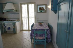 a kitchen with a table with a purple table cloth at Villa 7 posti a 3 minuti dal mare - Villa Carbone in Sperlonga
