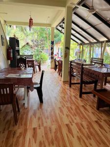 Un comedor con mesas y sillas de madera. en Lahiru Place, en Arugam Bay