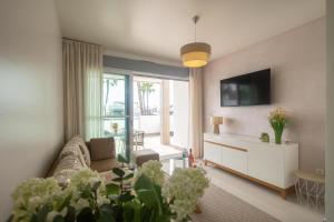 a living room with a couch and a tv at Mirador del Mar in Torrevieja