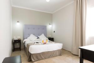 a hotel room with a bed with a tray on it at Hotel Toboso Chaparil in Nerja