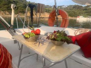 a table with two bowls of vegetables on a boat at Voilier à Porquerolles in Hyères