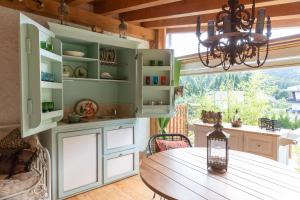 a kitchen with a wooden table and a chandelier at FORTE GALGI in Gallio +116 photos