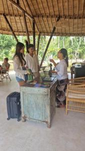 a group of people standing around a table with a laptop at Marilea Bamboo Villas Concept , Private pool, seaview, Adults only in Nusa Penida